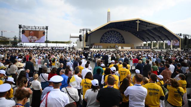 Der Papst feiert vor hundert-tausenden Menschen eine Messe auf der Place de la Concorde in Paris. Zu sehen sind Menschen-Massen, im Hintergrund die Bühne mit Papst Leo. 
