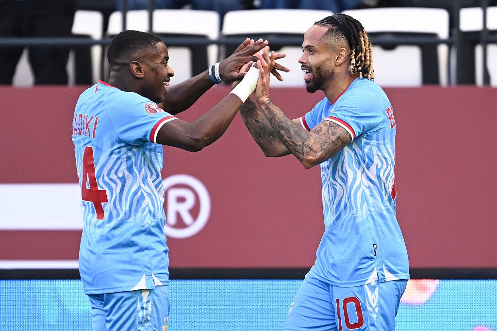 Democratic Republic Of Congo's forward #10 Theo Bongonda celebrates his goal with Democratic Republic Of Congo's midfielder #14 Noah Sadiki during the Africa Cup of Nations (CAN) Group D football match between Democratic Republic of Congo and Benin at Al Medina Stadium in Rabat on December 23, 2025. (Photo by SEBASTIEN BOZON / AFP)