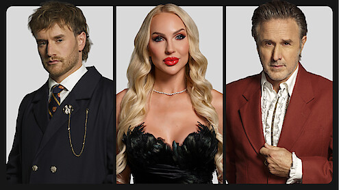 Three adults posing in formal attire against a neutral background; the man on the left wears a dark suit, the woman in the center wears a glamorous black dress, and the man on the right wears a red jacket with a white shirt.