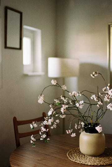 vase with blooming branches on a table in a softly lit room