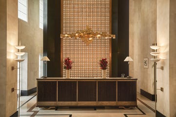 art deco hotel lobby with elegant reception desk and decorative lighting.