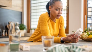 woman holding medications and reading instruction