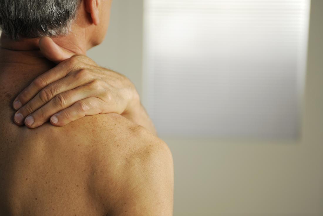 a man with bone cancer holds his shoulder