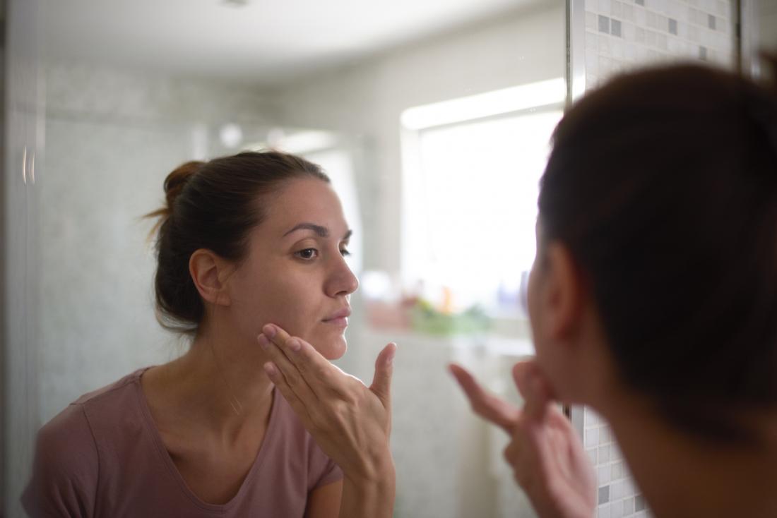 A person who may have BDD checking her face