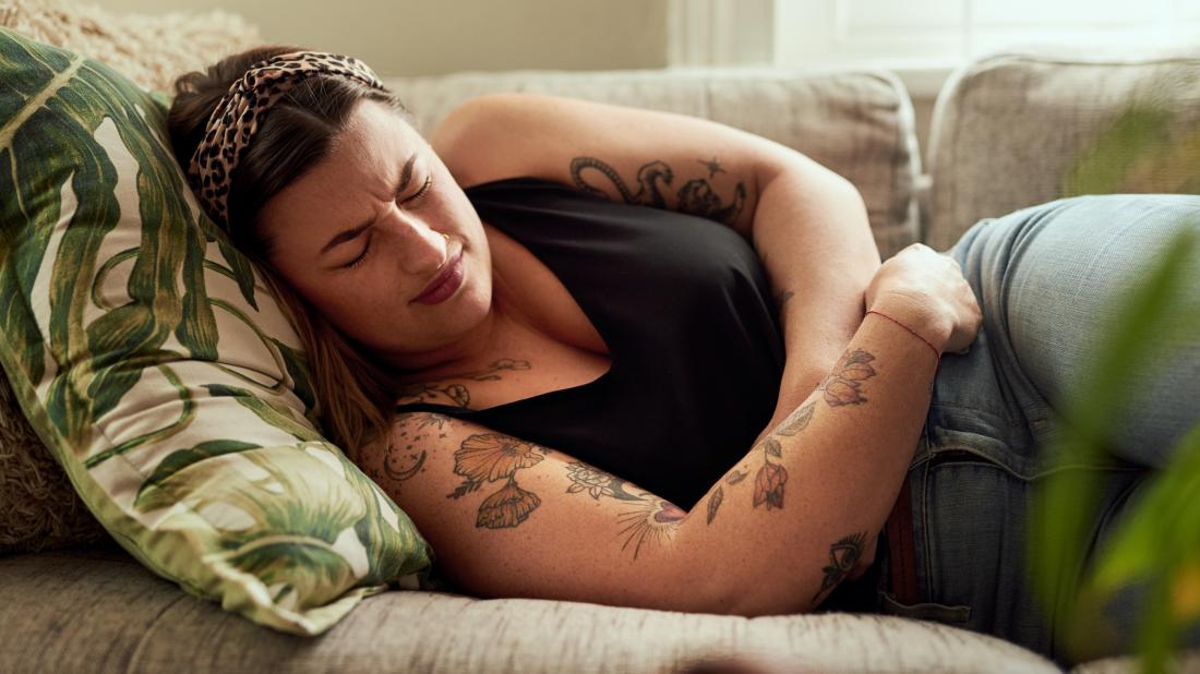 a woman holding her stomach because she is feeling bloated because of gluten intolerance