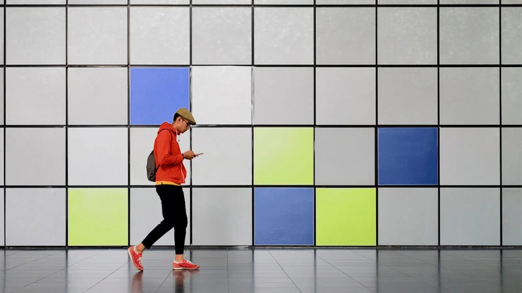 A man walking past coloured blocks on a wall as a way to represent the link between anxiety and depression 