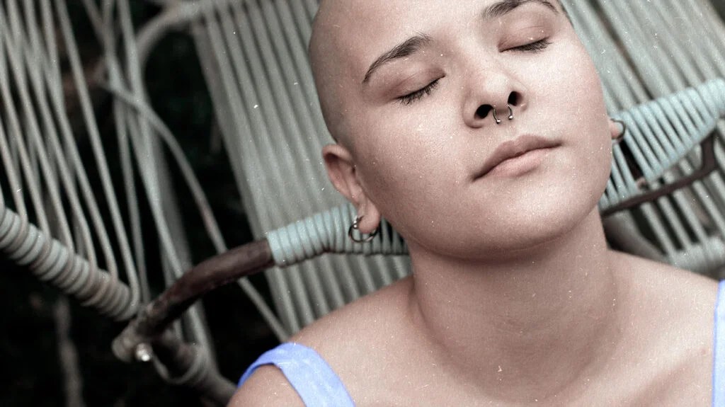 a woman with her eyes closed contemplating symptoms of leukemia symptoms 