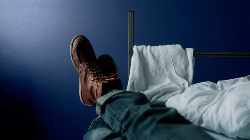 the feet of a man with fatigue sticking out the end of a bed