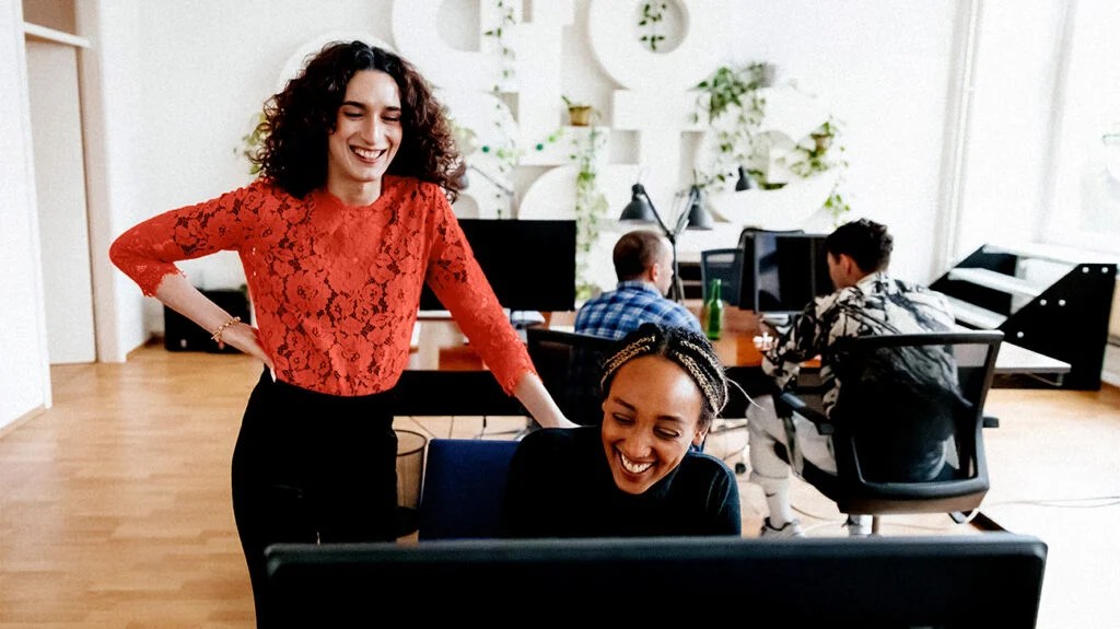 a transgender woman talking to a person in an office
