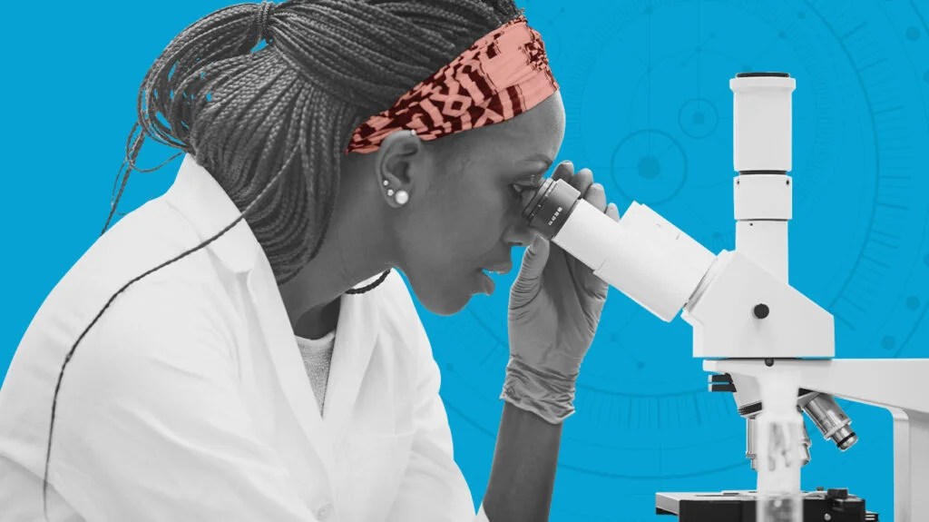 A person looking through a microscope to detect cancer cells.