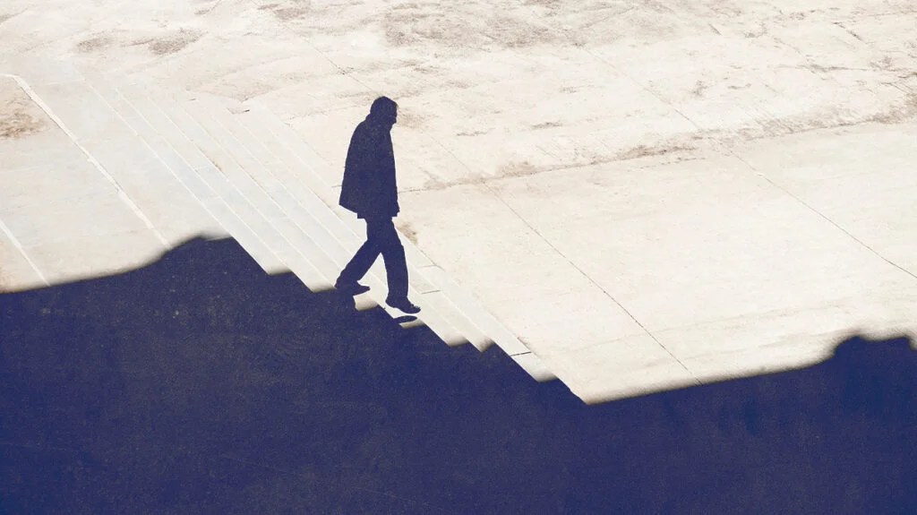silhouette of man living with acute myeloid leukemia in remission walking downstairs