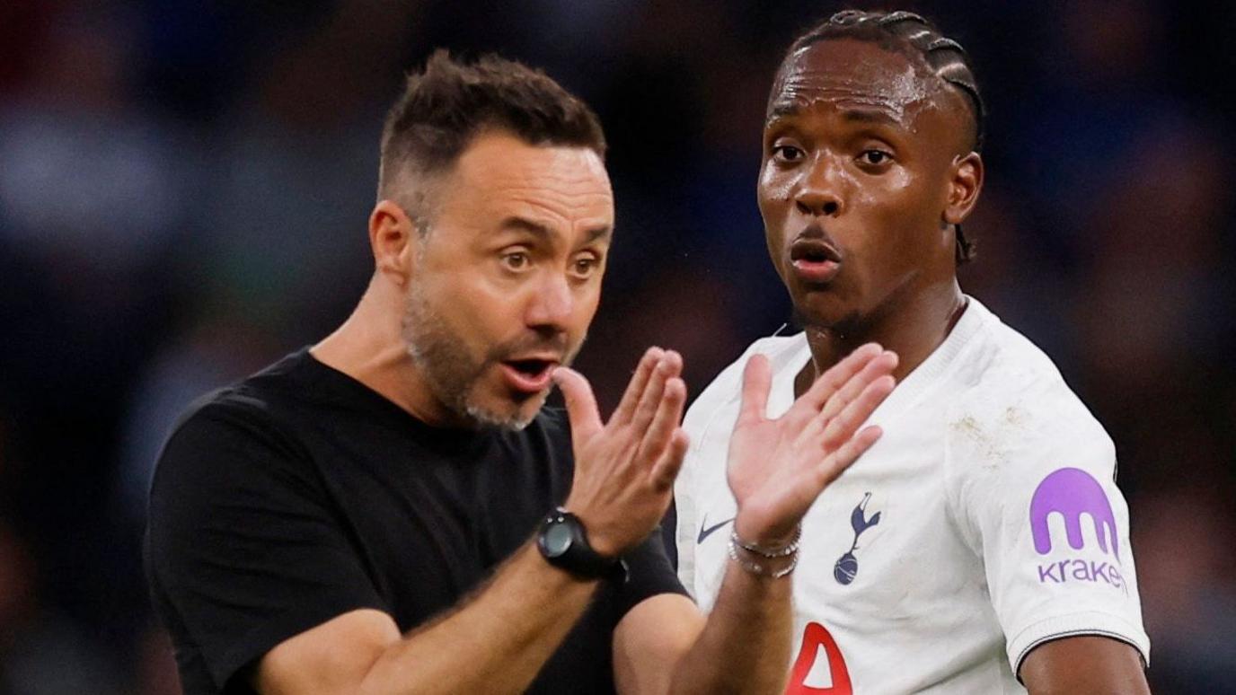 Spurs boss Roberto de Zerbi holds both hands out in front of him and stares towards them as he makes a point while standing alongside forward Mathys Tel