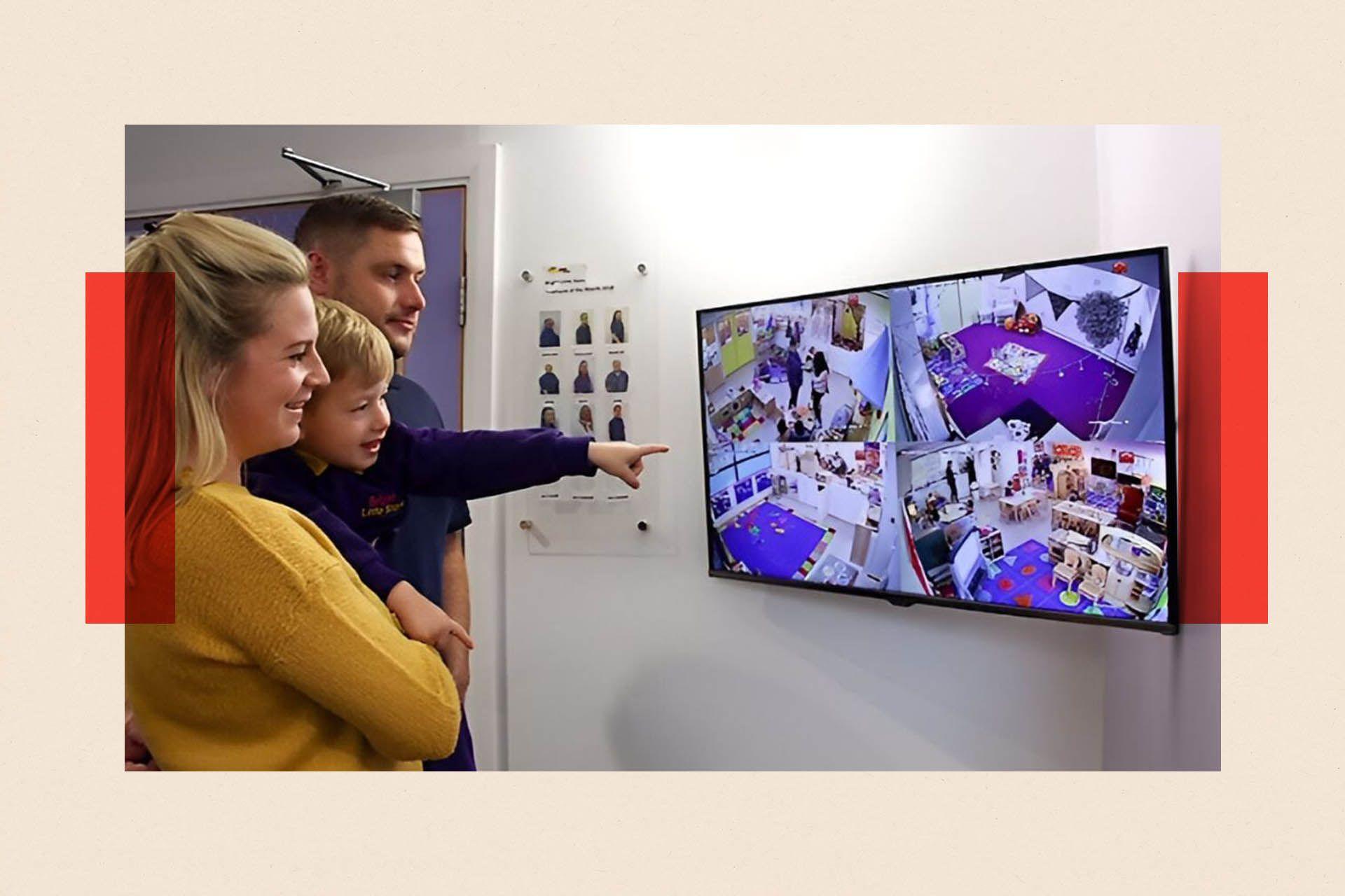 Parents with their child watch CCTV in a Bright Little Stars nursery 