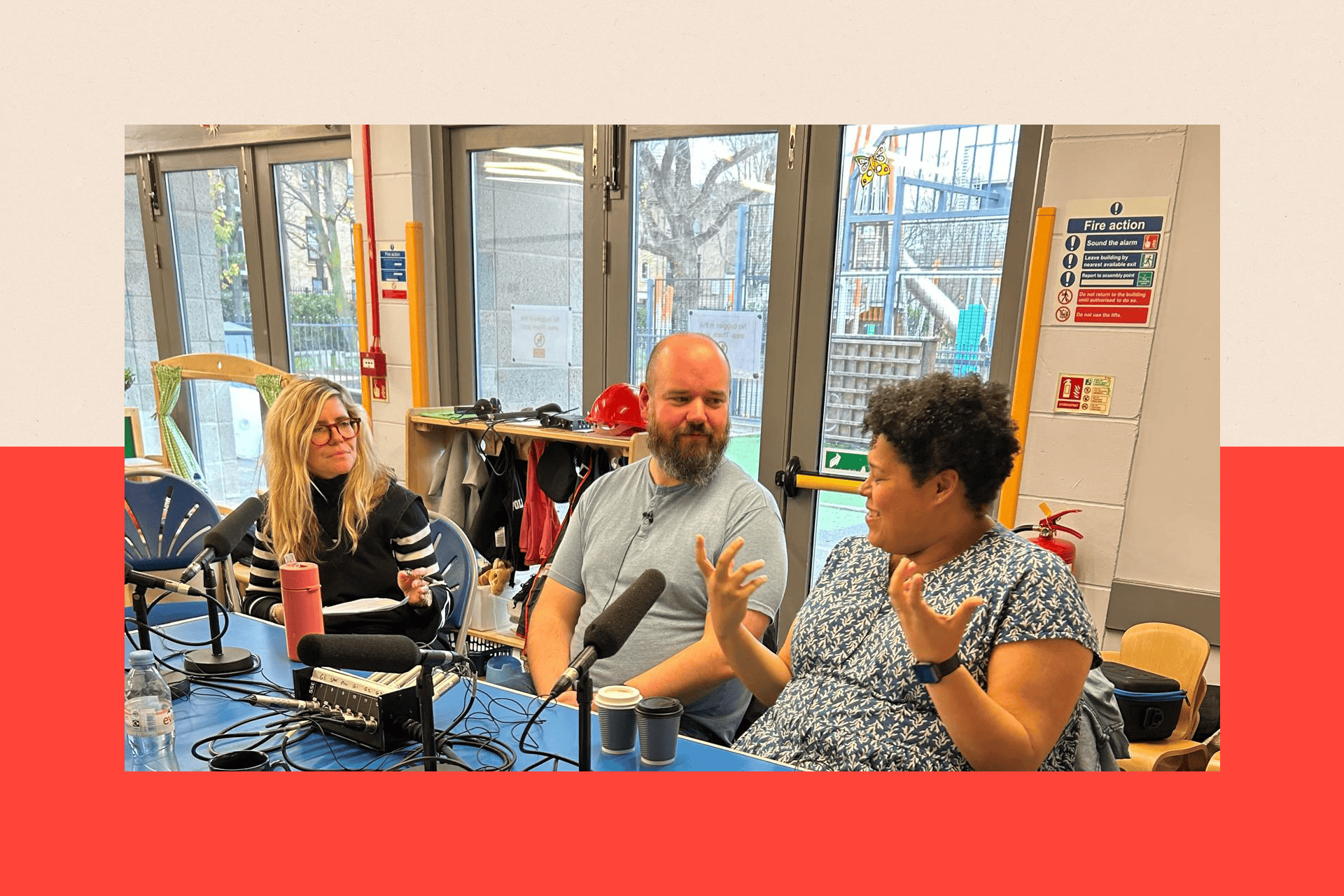 Three people sit talking at a table