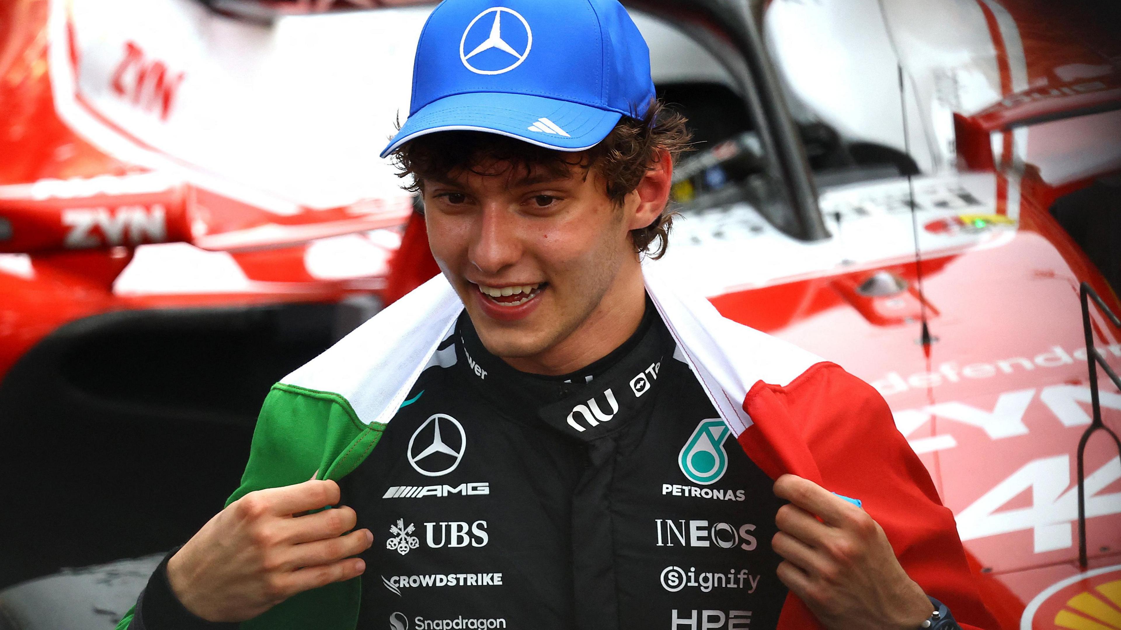Kimi Antonelli with the Italian flag draped around his shoulders after winning the Monaco Grand Prix