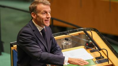 Emmanuel Macron passionately speaking at a podium