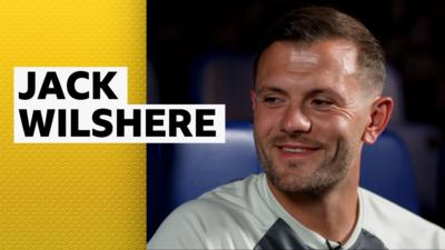 Jack Wilshere smiles in a Luton Town training top