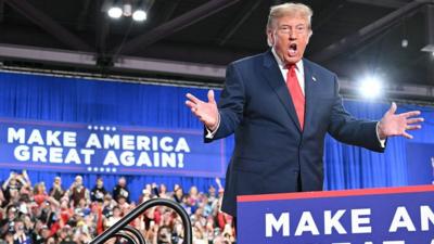 US President Donald Trump speaking at a podium 