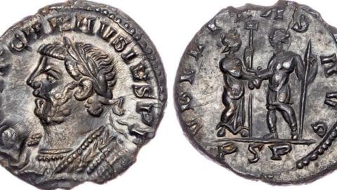 Both sides of a very misshapen and chipped silver Roman coin laid against a white background. One side features an emperor and the other features two Roman figures shaking hands.