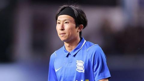 Kanya Fujimoto wearing a black hair band and a blue Birmingham City shirt
