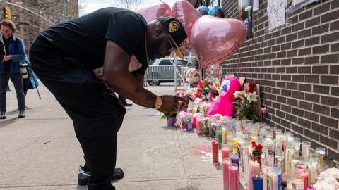 A mourner ties balloons to a memorial and vigil where a 7-month-old baby, Kaori Patterson-Moore, was killed by a stray bullet on April 1 while sitting in her stroller in Brooklyn on April 04, 2026, in New York City.