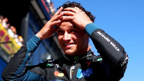 Lando Norris has both hands on his head and appears shocked after taking pole position for the Spanish Grand Prix