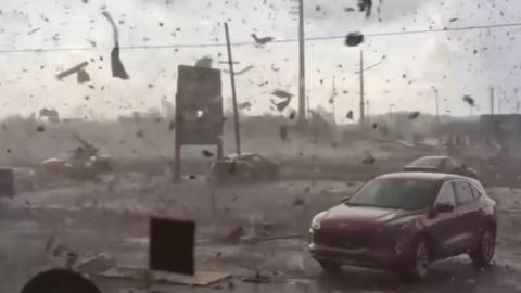 A car surrounded by flying debris 