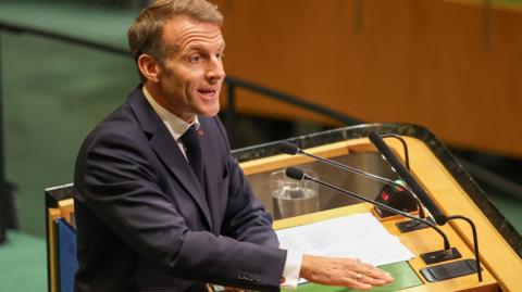 Emmanuel Macron passionately speaking at a podium