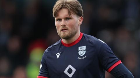 Noah Chilvers in action for Ross County in their dark blue home jersey