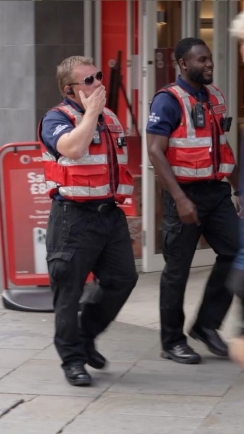 Two officers walking through a city centre. 
