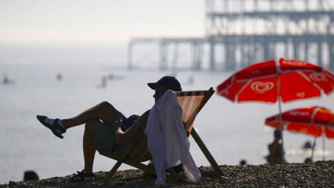 Man sits in deckchair on Brighton beach during early September heatwave
