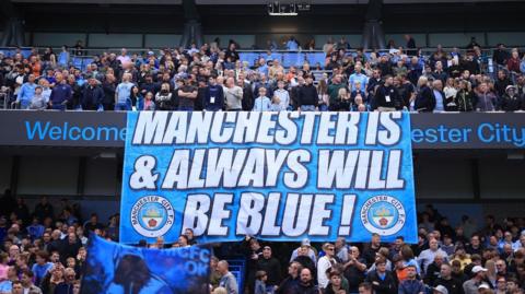 Man City fans around a banner