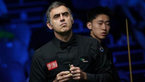 Ronnie O'Sullivan chalking his cue
