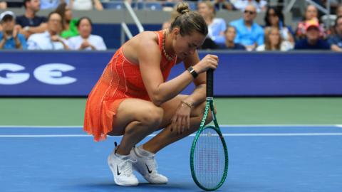 Aryna Sabalenka crouches over her racquet at the US Open