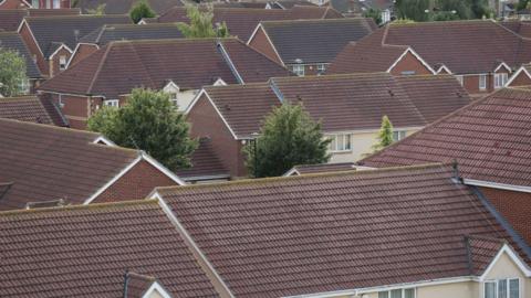 Aerial view of a housing estate showing the roofs of residential properties.