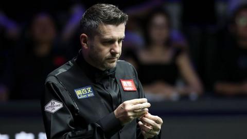 Mark Selby chalks his cue 