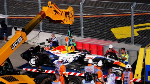 Arvid Lindblad's damaged Racing Bulls is removed from the Madring circuit by a rescue vehicle after his crash during second practice for the Spanish Grand Prix