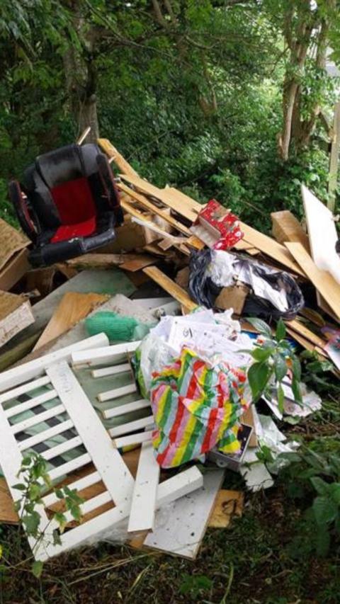 A pile of rubbish including household items like an office chair.