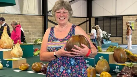 Maggie, winner of the aubergine category, holding her winning aubergine