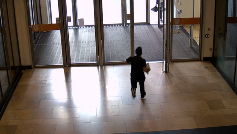 A man walking out of shopping centre doors 