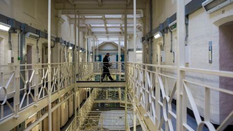 A prisoner officer walks along a balcony in HMP Portland,  Dorset.