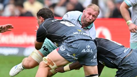 Ospreys flanker Ross Moriarty winces while tackled by Sharks