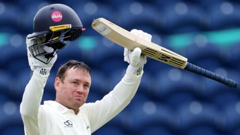 Colin Ingram holds bat and helmet aloft