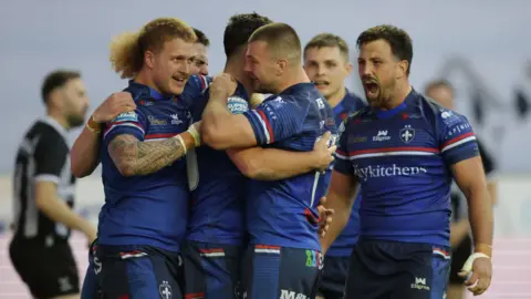 Wakefield players celebrate a try against Wigan