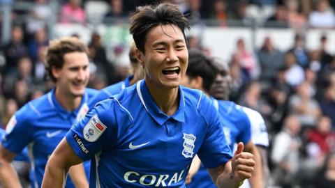 Birmingham players celebrate scoring with big smiles on their faces
