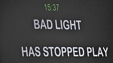 Message telling spectators bad light has stopped play is shown on the big screen