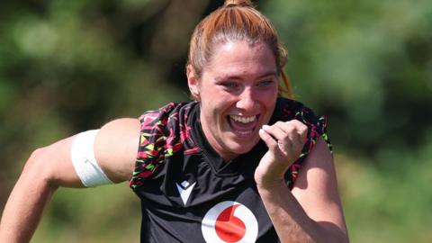 A smiling Georgia Evans running during Wales training