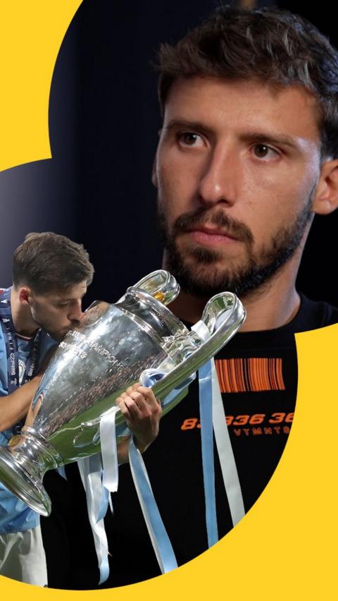 Ruben Dias looks at a cutout of himself kissing the Champions League