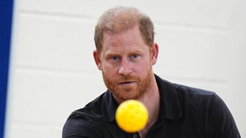Prince Harry returns a ball during a school visit linked to the Invictus Games Birmingham 2027.