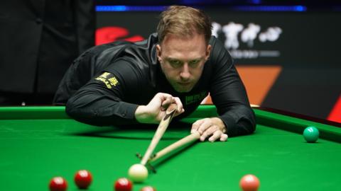 Judd Trump plays a shot with the rest